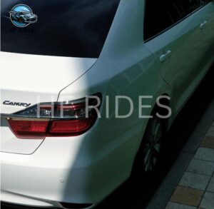 A Toyota Camry displayed prominently, showcasing its sleek design and modern features in a dealership setting.