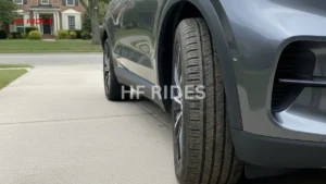 Front tire of a gray SUV parked on the roadside, showcasing the vehicle's profile against the pavement. - Can I replace just one tire on my car?